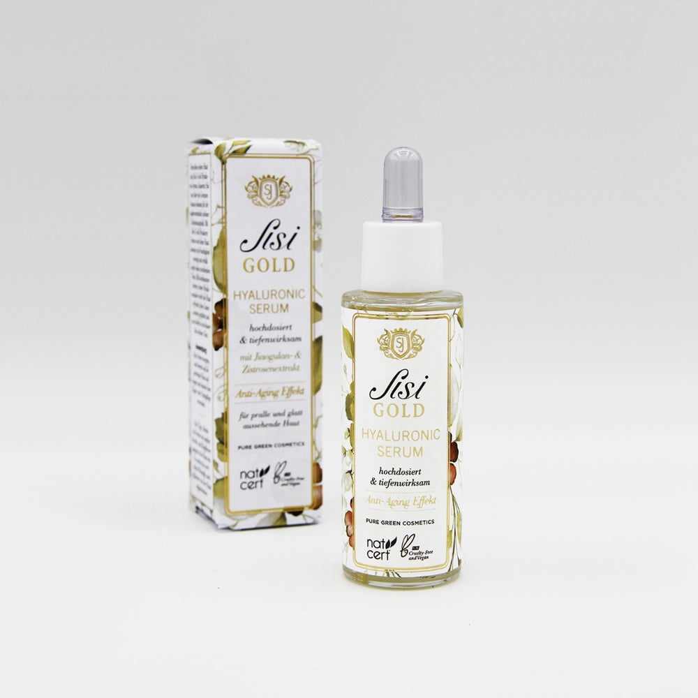 Hyaluron-Serum mit Traubenkernextrakt in weißer Glasflasche mit goldenen Details, vor passender Schachtel. Bio, vegan, feuchtigkeitsspendend und glättend. NATRUE-zertifiziert.