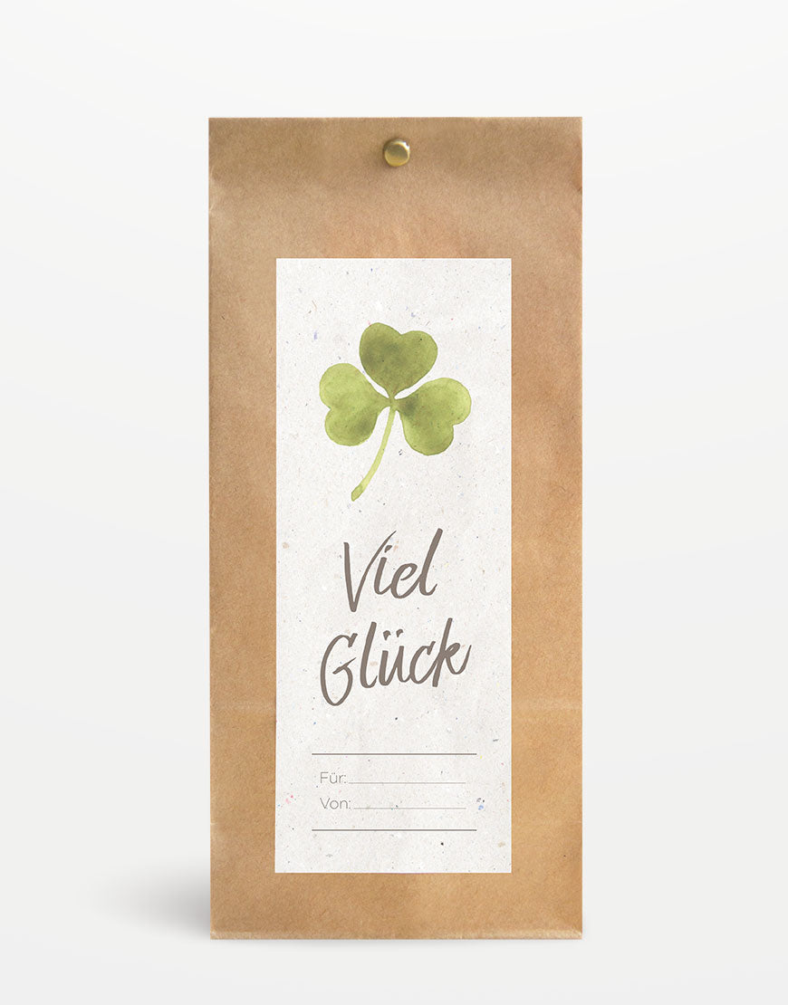 Geschenkverpackung „Viel Glück“ aus Papier mit Aquarell-Kleeblatt und personalisierbarem Etikett, geeignet für 2-3 Tiroler-Naturkosmetik-Produkte. Nachhaltig gestaltet für persönliche Botschaften.