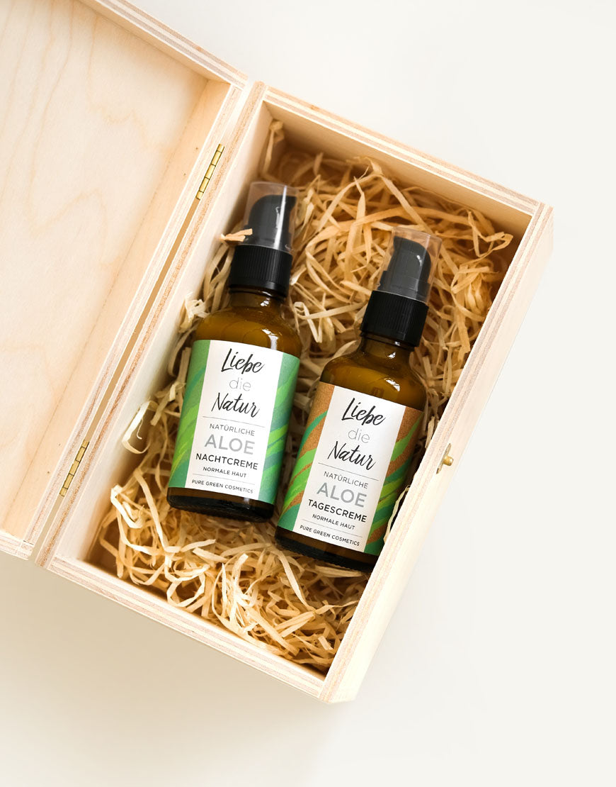 Gesichtspflegeset für wohltuende & entspannende Gesichtspflege | Bio & Vegan: Zwei amberfarbene Pumpflaschen in offener Holzbox, gefüllt mit Aloe Tages- und Nachtcreme.