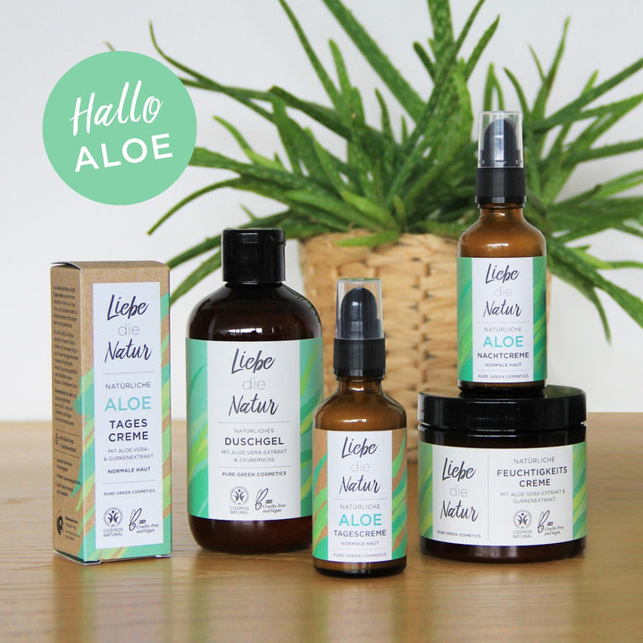 Feuchtigkeitscreme mit Aloe-Vera & Gurkenwasser für intensive Feuchtigkeit & geschmeidige Haut, umgeben von Aloe-basierten Pflegeprodukten auf einem Holztisch, mit „Hallo ALOE.“ Grafik im Hintergrund.