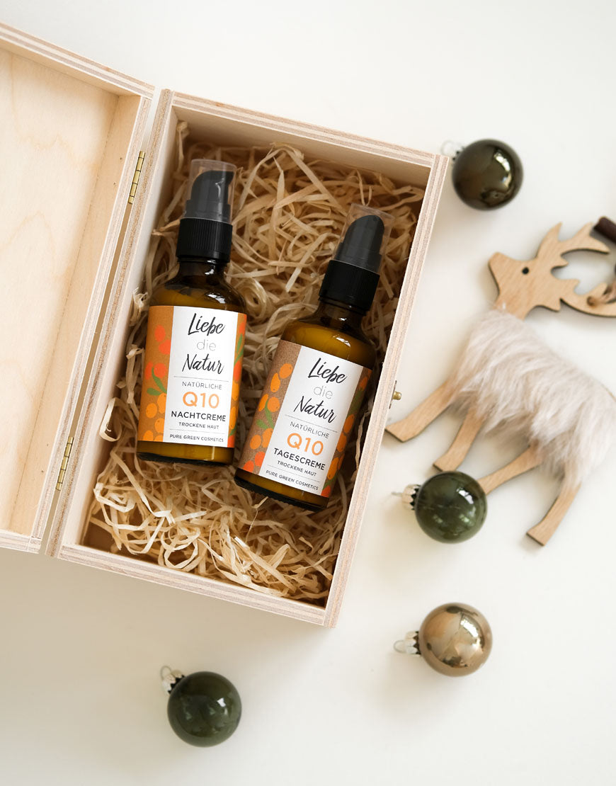 Q10 Anti-Aging Gesichtspflege-Set mit Coenzym Q10 & Hyaluronsäure in Holzkiste, mit Tages- und Nachtcreme, daneben Holzrentier und Weihnachtskugeln.