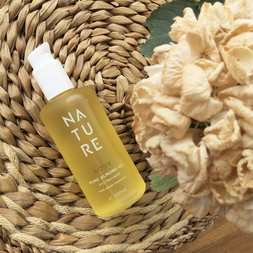 200 ml Flasche Reines Mandelöl Pflegeöl auf Strohunterlage mit getrockneten Blumen, bietet intensive Pflege für Haut und Haare, Bio & Vegan, aus Österreich.