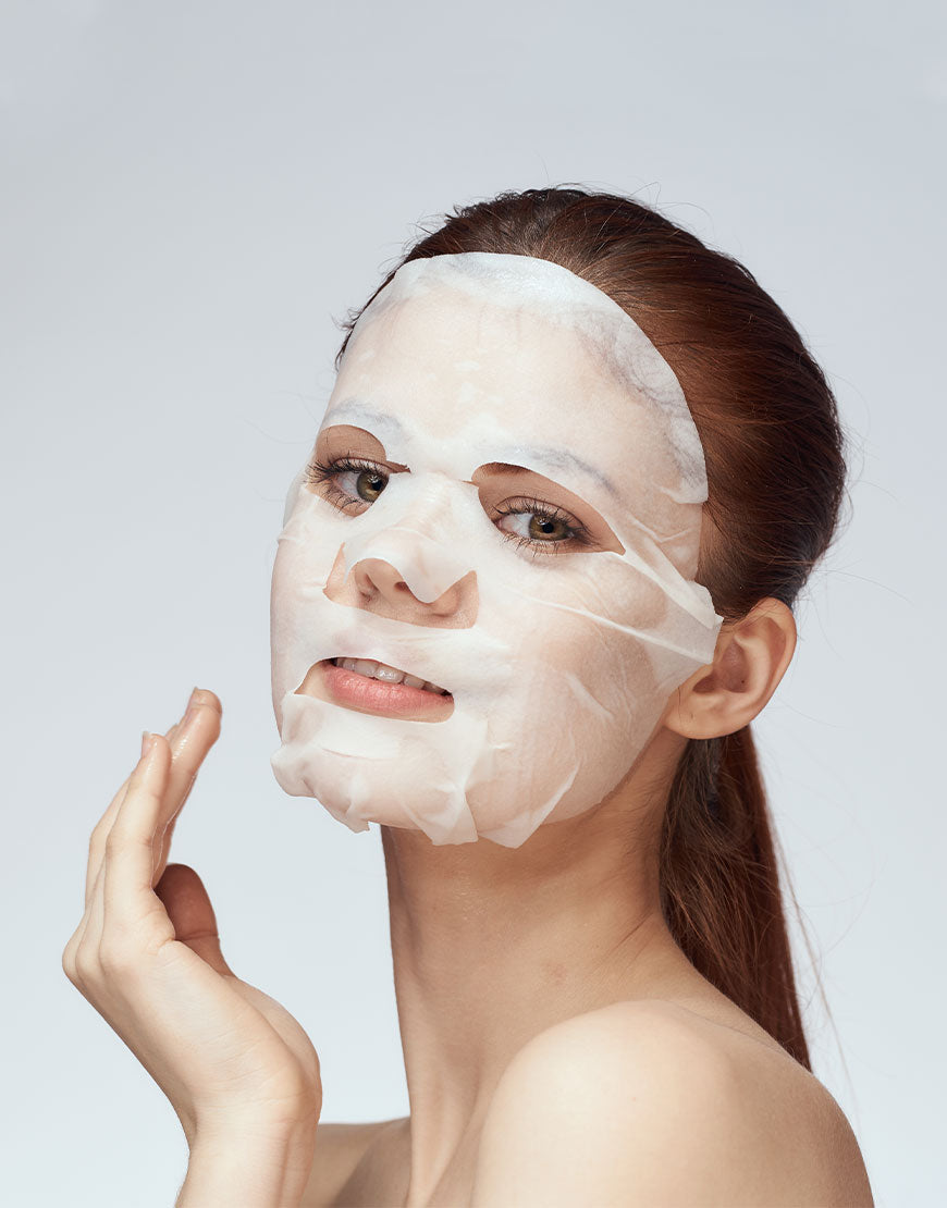 Junge Frau trägt die Anti-Aging Tuchmaske mit Feigenkaktus- und Gerstenextrakt; sanfte Pflege für straffe, intensiv mit Feuchtigkeit versorgte Haut. Dermatologisch getestet.