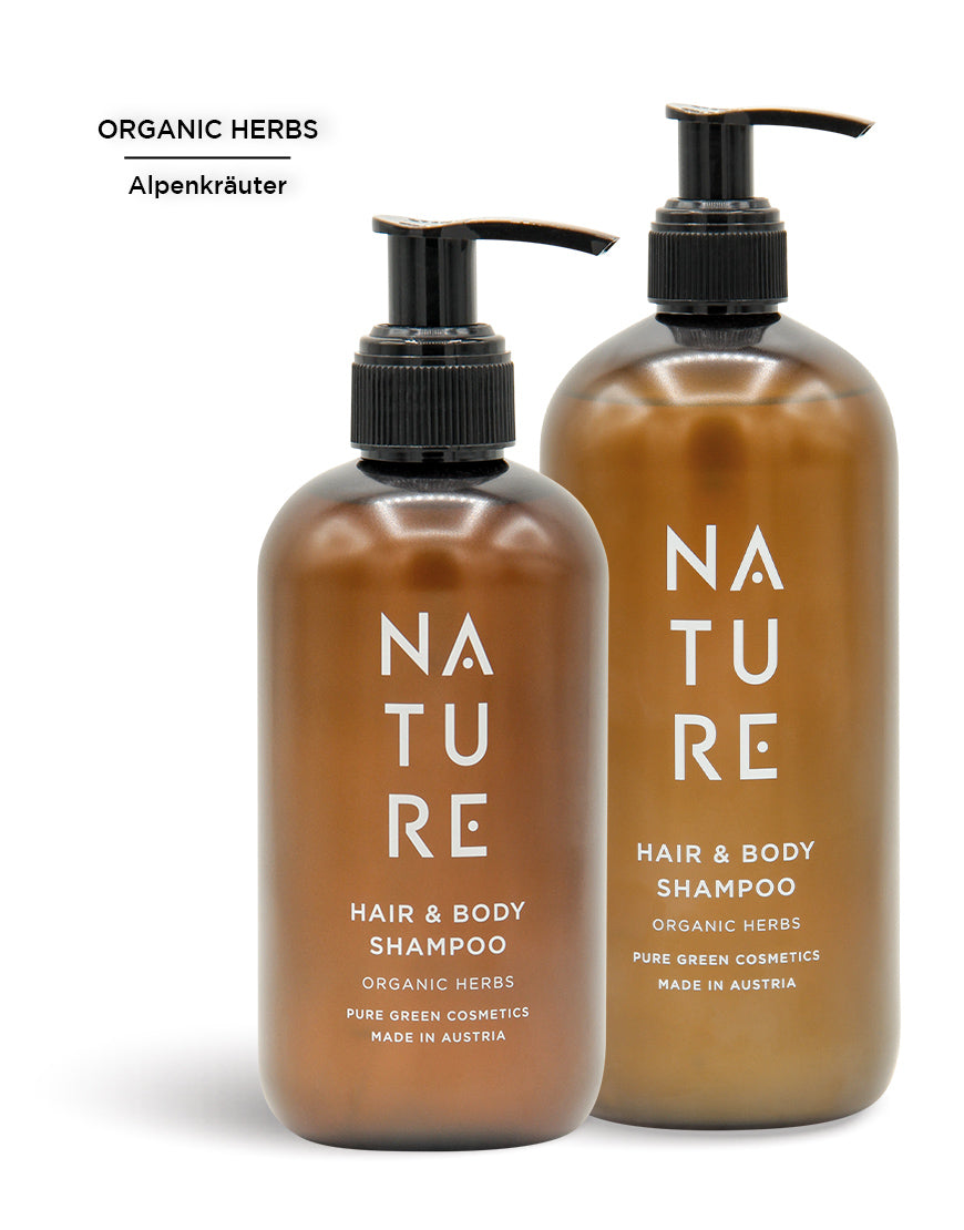 Zwei bernsteinfarbene Pumpflaschen des „NATURE“ Hair-&-Body-Shampoos mit Apfelsaft und pflanzlichem Glycerin für sanfte Reinigung und seidiges Haar. Bio und vegan.