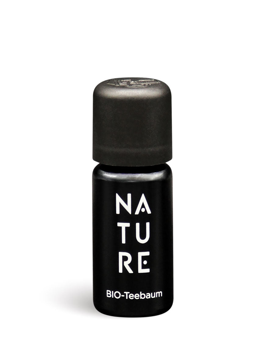 Schwarze Glasflasche mit schwarzem Deckel, etikettiert „NATURE“ und „BIO-Teebaum“, enthält 100% reines, beruhigendes Teebaumöl für hautreinigende Aromatherapie, bio und vegan.