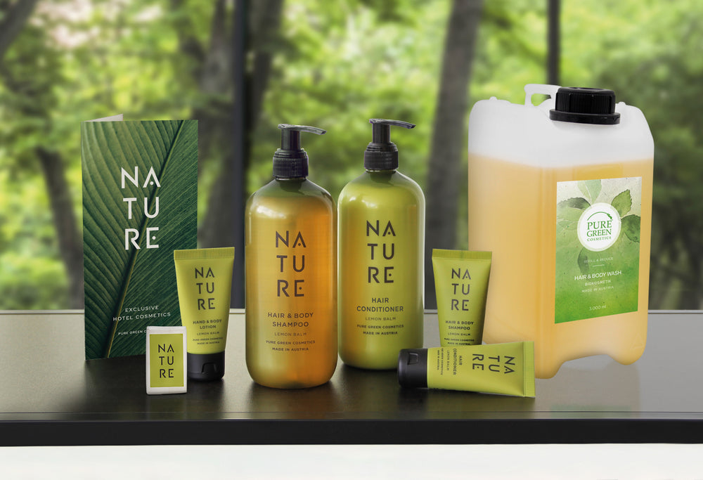 Sortiment grüner Pflegeprodukte: Broschüre, Seife, Lotion mit Aprikosenextrakt, Shampoo, Conditioner, alles in Reisegröße und Nachfüllkanister. Bio, vegan, hautpflegend.