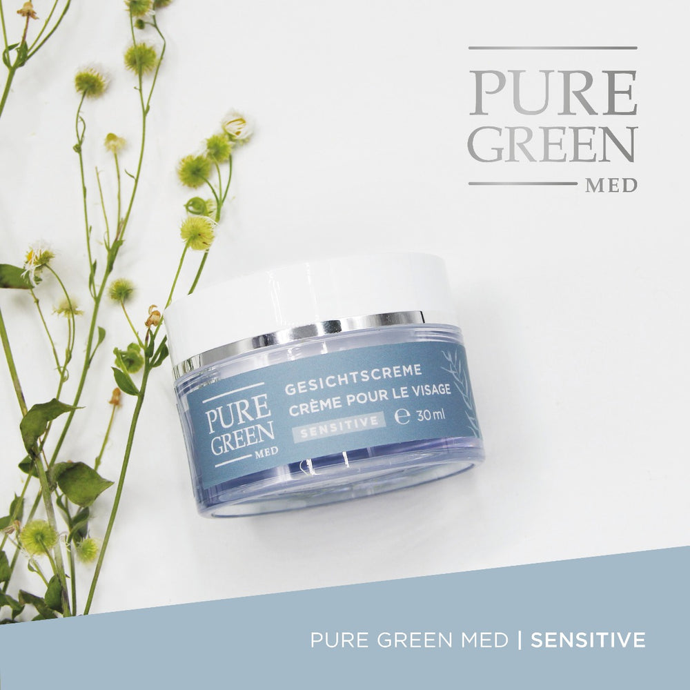 Gesichtscreme Sensitive mit Aloe-Vera & Calendulaextrakt in frosted-blauem 30 ml Tiegel, umgeben von grünen Wildblumen, für intensive Feuchtigkeit und gestärkte Hautschutzbarriere.